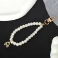 Detailopname van een elegante witte parelketting met een gouden hartje en sluiting - Letter A(A)
