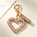 Gros plan détaillé d'un porte-clés en forme de cœur évidé avec des strass étincelants. - Porte-clés Cœur Ajouré Strass / Or champagne