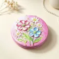Detail showing the 3D oil painting flower pattern on a pink folding compact mirror. - Oil Painting Flowers - Pink Daisy