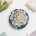 Detailed macro view of a portable vintage ethnic style makeup mirror with mandala pattern - Lake Blue Pink