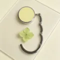 Minimalist portable silver table hook for bags with a pastel yellow circular top - Folding Hook / Creamy Yellow