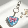 Herzförmiger Spiegel-Schlüsselanhänger mit einer rosa Schleife für elegante Handtaschen - Himmelblauer Spiegel Rosa Schleife