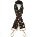 Detailed view of an adjustable leopard print bag strap featuring gold-tone swivel hooks - Black Coffee Cream Leopard (No. 4) / Silver Buckle