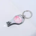 Hoogwaardige close-up van een zilveren nagelknipper-sleutelhanger met roze marmeren inleg - Ronde Stijl 3