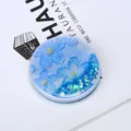 Close-up of portable round makeup mirror with blue floral quicksand glitter effect. - 7.5*7.5*1.0cm / Blue