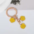 Detailed close-up of a boutique yellow rose craft keychain with golden ring and chain - Yellow