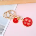 Detailed view of a red enamel keychain featuring gold Peace and Joy Chinese engraving - Circle Peace and Joy (Apple Charm)