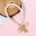 Detailed shot of pearl phone charm with pink bow and vintage golden coin pendant - Pink Bow & Rectangular Portrait Tag Style (Style 6)