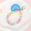 Detailweergave van kleurrijke macaron kralen telefoonaanvulling met blauwe hartbedel - Macaron Kralenketting + Blauw Hart