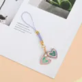 Gros plan d'un cordon de téléphone violet avec des breloques de cœur en émail coloré - Cœur Coloré