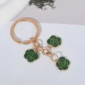 Close-up detail of the green rose enamel charms on the gold-toned craft keychain pendant - Green