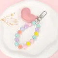 Detailweergave van macaron kralen telefoonkoord met een roze lederen hartvormige hanger - Macaron Kralenketting + Roze Hart