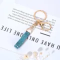 Κομψό μπρελόκ με μπλε στραφταλιζέ πέτρες και χρυσό κούμπωμα σε διακοσμητική λευκή κάρτα - Μπλε