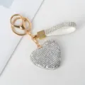 Detailopname van een sprankelende hartvormige sleutelhanger met strass en gouden haak. - Zilver Diamant