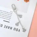 Close-up of silver clover keychain pendant with glittering rhinestones on a white card - Silver