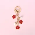 Detail of red enamel cherry blossoms and white faux pearls on a golden metal keychain - Plum Blossom / Red