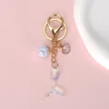 Detail of an iridescent gradient mermaid tail keychain with shell and glitter ball - Laser Gradient Tail (Style 05)