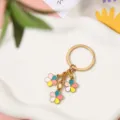 Detail view of colorful enamel flower charms on a gold-plated metal keychain - Colorful