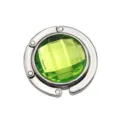 Detailed view of a foldable metal purse hook with a faceted green crystal center - 4.50cm / Green (Rhinestone Style)