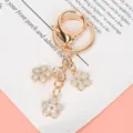 Golden metal cherry blossom keychain featuring elegant pearly white flower charms - Lobster Clasp Style / White