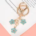 Elegant gold cherry blossom metal keychain with three blue enamel flower charms for bags - Lobster Clasp Style / Sky Blue
