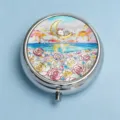 Close-up of a round metal pill box featuring an artistic rabbit and moon design - Seaside Starry Flower Sea (Round Silver Frame)