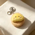 Primo piano dettagliato di un simpatico specchio da tasca in peluche a pulcino con portachiavi - Forma di Anatra / Marrone