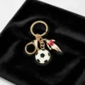 Vue détaillée d'un porte-clés de football en métal doré avec figurine de joueur - Style Football 【Personnage】