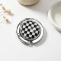 Detailed view of a portable foldable metal bag hook with a black and white checkered design - Checkerboard Pattern / Silver