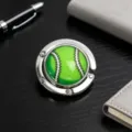 Nahaufnahme eines tragbaren faltbaren Handtaschenhalters aus Metall mit Baseball-Design - 绿色棒球款