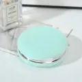 Close-up of mint green plush round compact mirror with silver metal frame - 7.5cm / Green