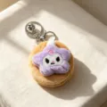 Primo piano di uno specchio macaron di peluche con stella viola e portachiavi in argento - Forma di Stella / Marrone