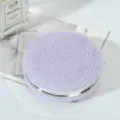 Detailed close-up of a round purple faux fur makeup mirror with polished silver frame - 7.5cm / Purple