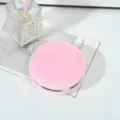 Close-up of pink faux fur round double-sided makeup mirror with silver trim - 7.5cm / Pink