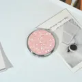 Miroir de poche rond en métal avec une finition pailletée rose scintillante pour le maquillage - Paillettes