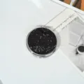 Vue détaillée d'un miroir de maquillage rond portable à paillettes noires sur table - Noir