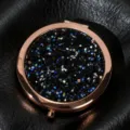 Detailed close-up of rose gold folding makeup mirror with sparkling black crystal inlay - 70mm / Obsidian color (rose gold)