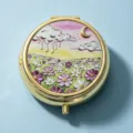Elegant round golden pill box featuring a beautiful embroidered flower and moon landscape. - Round Purple Sunset Floral Night / 2 Compartments / Gold