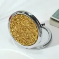 Close-up of golden rhinestone lid on a round folding metal makeup mirror - 70mm / Champagne gold diamond (silver frame)