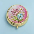 Elegant round gold metal pill box featuring a vibrant pink floral embossed lid design - Pink & Blue Contrast Flowers (Round Gold Frame)
