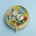 Elegant round golden metal pill box featuring colorful 3D floral embossed lid pattern - Clear Blue & White Camellia (Round Gold Frame)