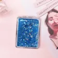Detailed macro view of portable blue quicksand folding makeup mirror with heart-shaped glitter - Blue-Square