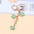 Elegant gold-tone keychain featuring three light green maple leaf charms for bag decoration. - Green Style