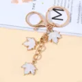 Golden metal keychain with three white enamel maple leaf charms as bag accessories - White Style