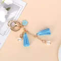 Detail of cute light blue keychain with flower charm, tassels, and faux pearls. - Blue