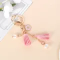 Close-up of pink cherry blossom keychain with soft tassels and white pearls - Pink