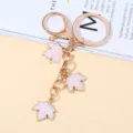 Gold-plated metal keychain with three pink maple leaf enamel charms for bag decoration - Pink Style