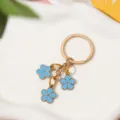 Blue enamel flower keychain with three floral charms in gold finish for bag decor - Sky Blue