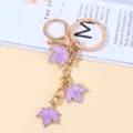 Elegant purple maple leaf keychain with triple pendants and polished gold-tone metal hardware - Purple Character
