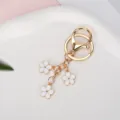 Elegant gold metal keychain with three small white enamel flower charms for bags - White With Lobster Clasp